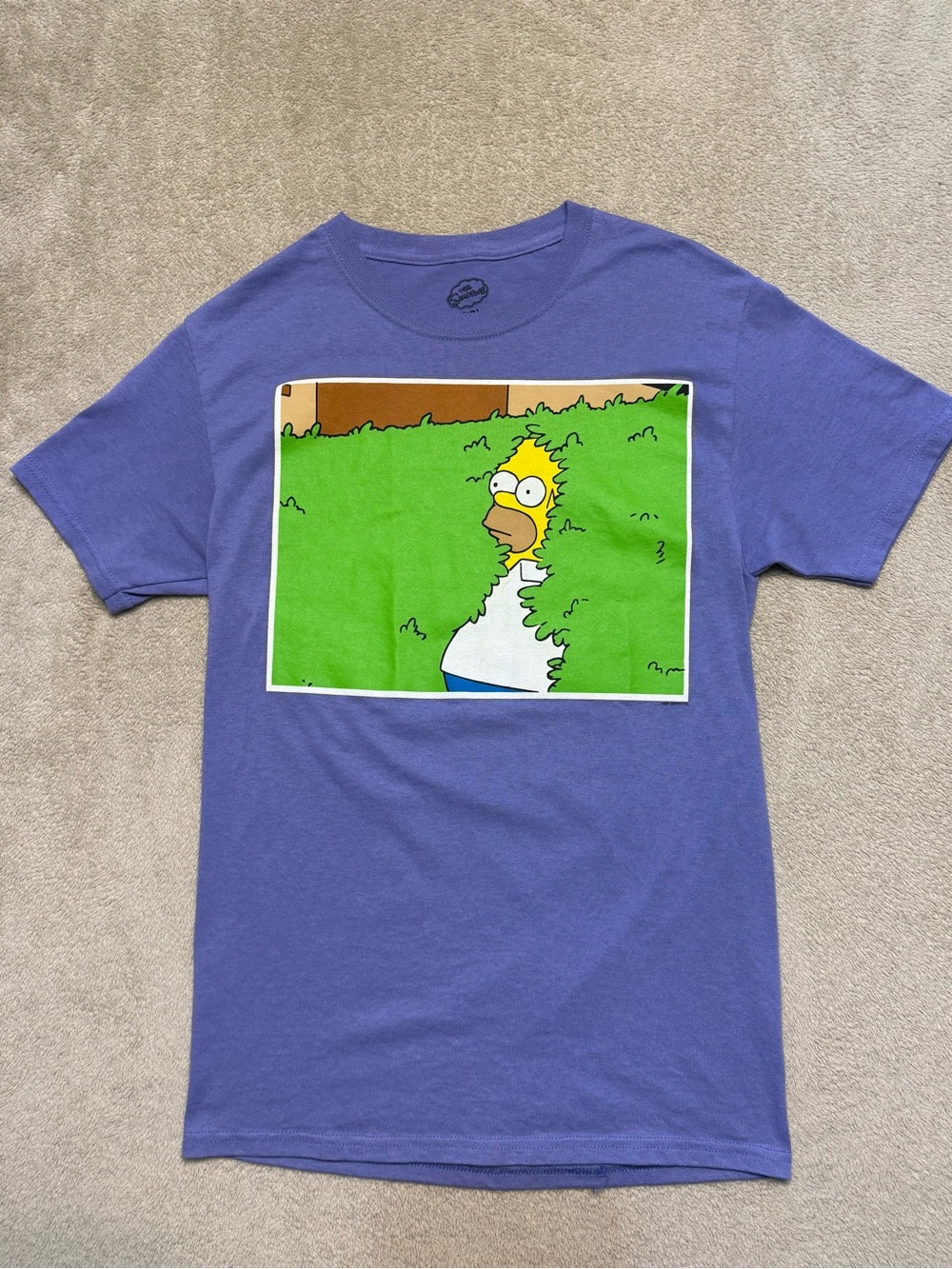 Purple Homer Simpson disappears into the bushes graphic tee in a men’s small